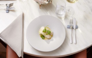 Pescada Confit e Caldo de Acorda Alentejana. "No BAHR trabalhamos muito o peixe, até porque eu e o Nuno gostamos muito de o fazer. Este prato é um exemplo do nosso trabalho com esse produto onde servimos pescada, um peixe pouco usual de servir neste tipo de espaços, com um caldo de açorda alentejana, que leva sames de bacalhau. Costumo dizer que é um híbrido entre um bacalhau à Brás — só que leva pescada — e uma açorda alentejana." Foto: DR